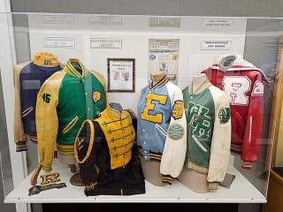 Historical varsity jackets from over the decades inside a display case